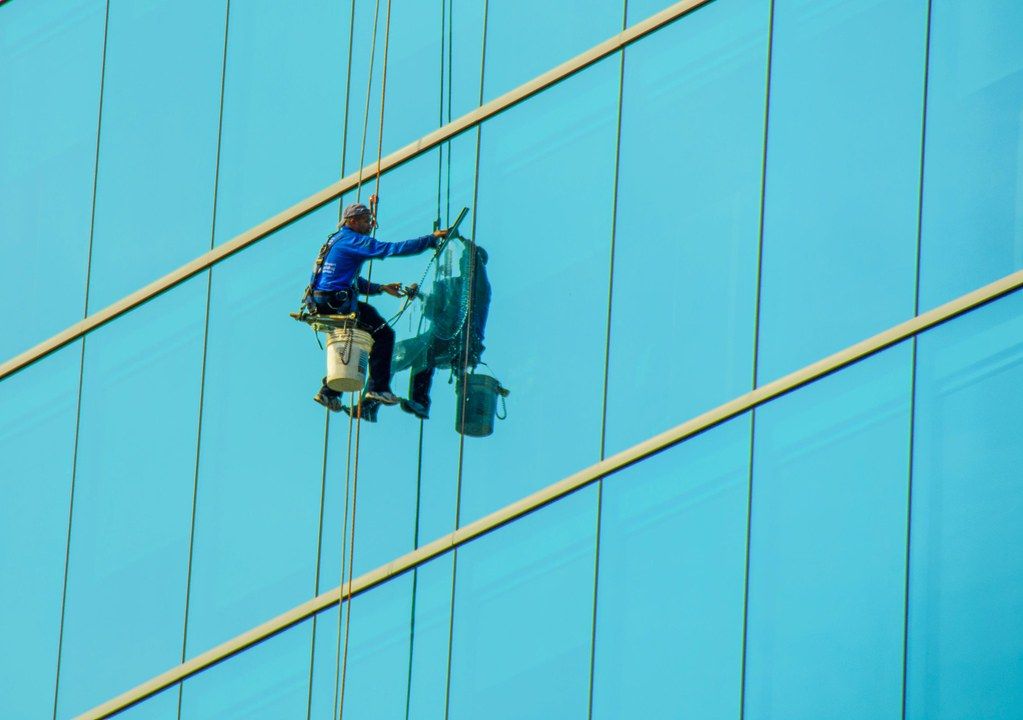 Technician cleaning a glass building facade